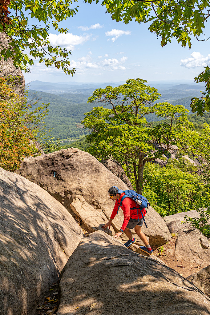 Man climbing up rocks along the Old Rag Rock Scramble in Virginia.