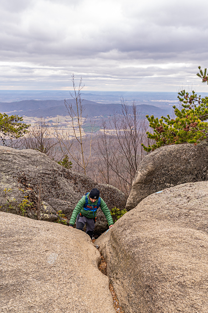 Man navigating up a giant rock along the Old Rag Rock Scramble in Virginia.