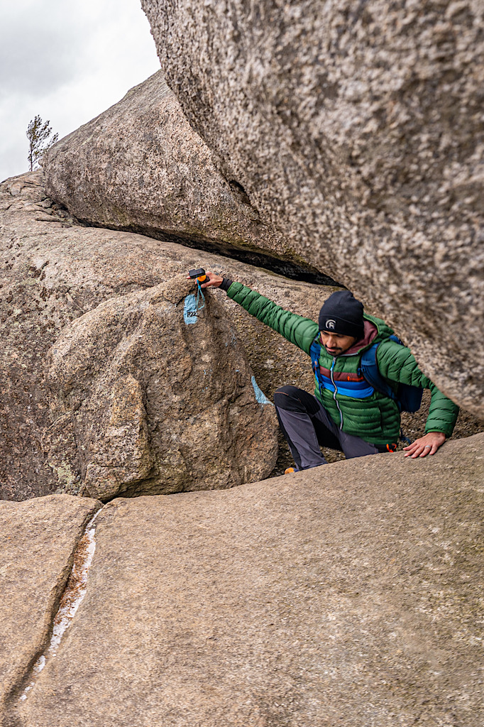 Man climbing up a giant rock along the Old Rag Rock Scramble in Virginia.