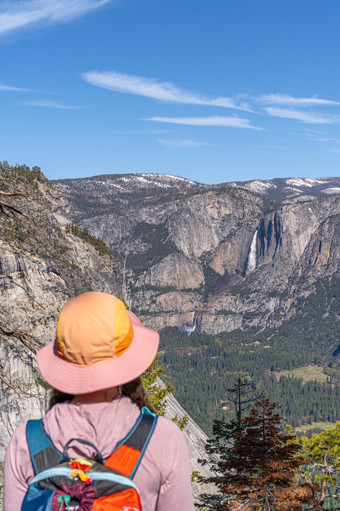 Woman looking at Yosemite Falls from Panorama Trail in Yosemite National Park.