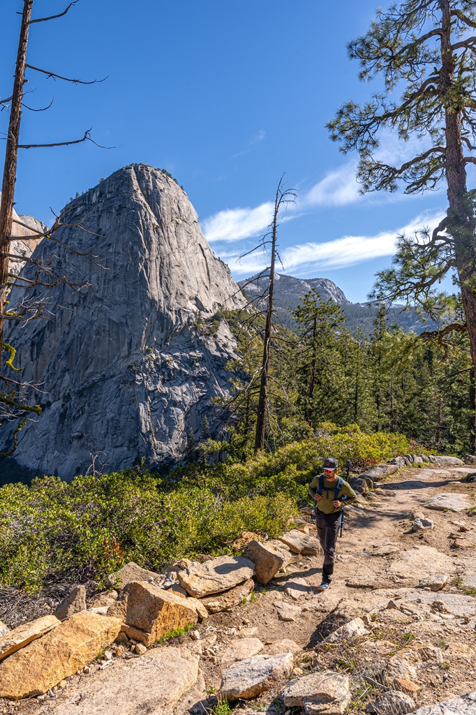 Man hiking along the Panorama Trail with Liberty Cap in the background.