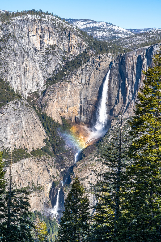 Rainbow at the base of Upper Yosemite Fall seen from the Four Mile Trail in Yosemite National Park.