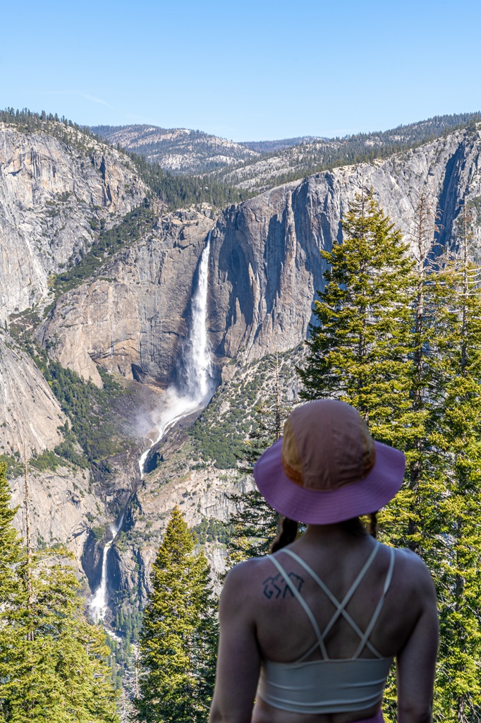 Woman looking at Yosemite Falls from the Four Mile Trail in Yosemite National Park.