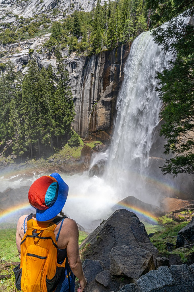 Woman looking up at Vernal Fall along the Mist Trail in Yosemite National Park.