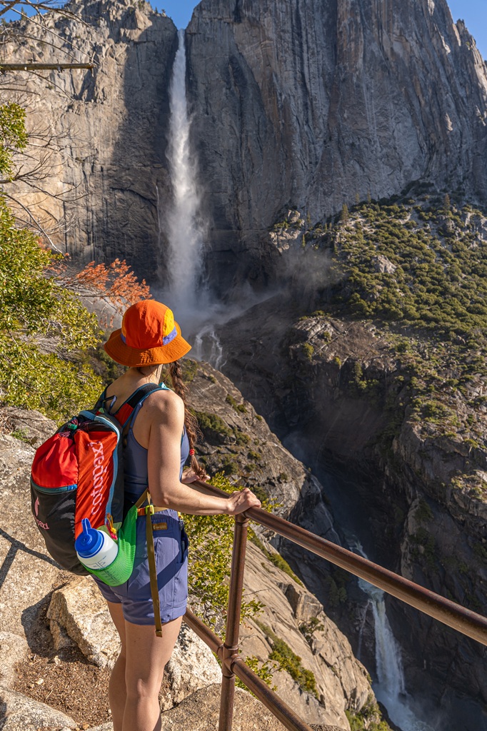 Woman standing at a viewpoint of Yosemite Falls off the Upper Yosemite Fall Trail.