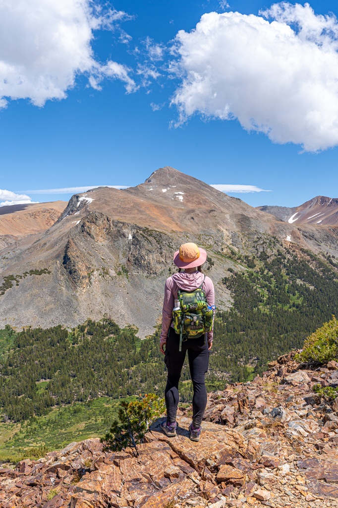 Woman standing on a trail looking at Mount Dana in Yosemite National Park.