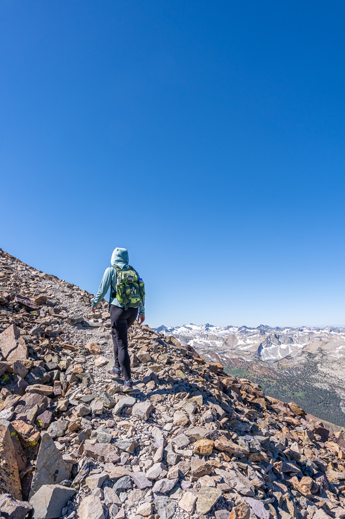 Woman hiking up a steep, rocky section of the Mount Dana Trail.