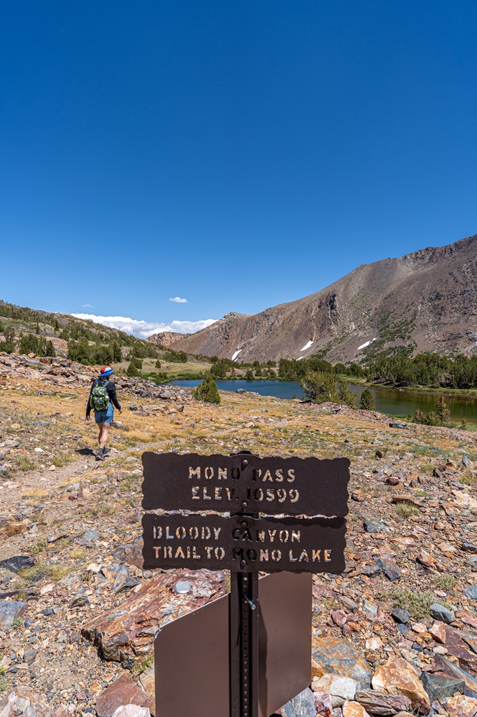 Mono Pass trail sign stating the elevation at 10,599 feet and another sign below it stating Bloody Canyon Trail to Mono Lake.