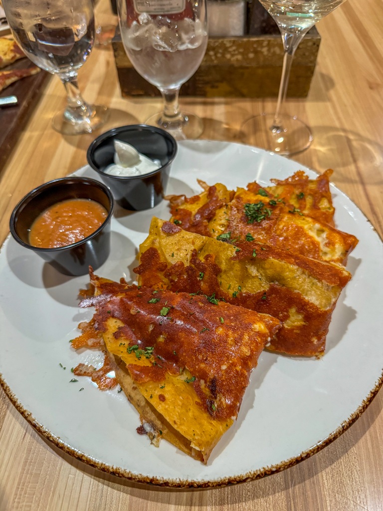 Inside-out crusted avocado quesadilla with 2 small cups of sour cream and sauce from Jackalope's Bar and Grill at Tenaya Lodge.
