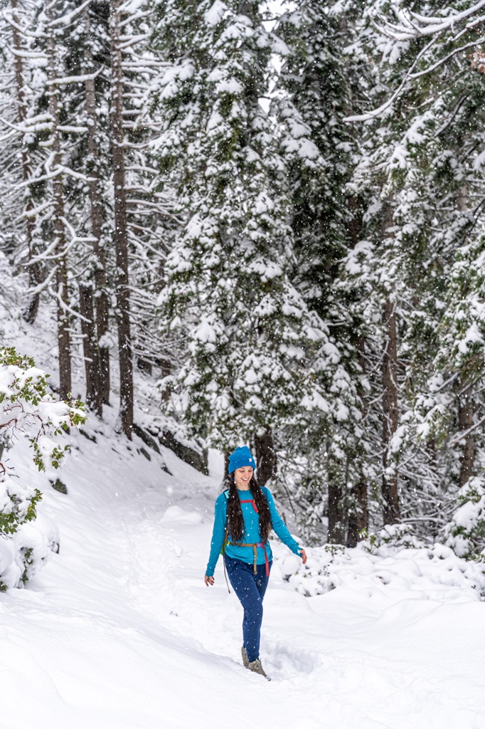 Woman hiking through the snow in Yosemite.