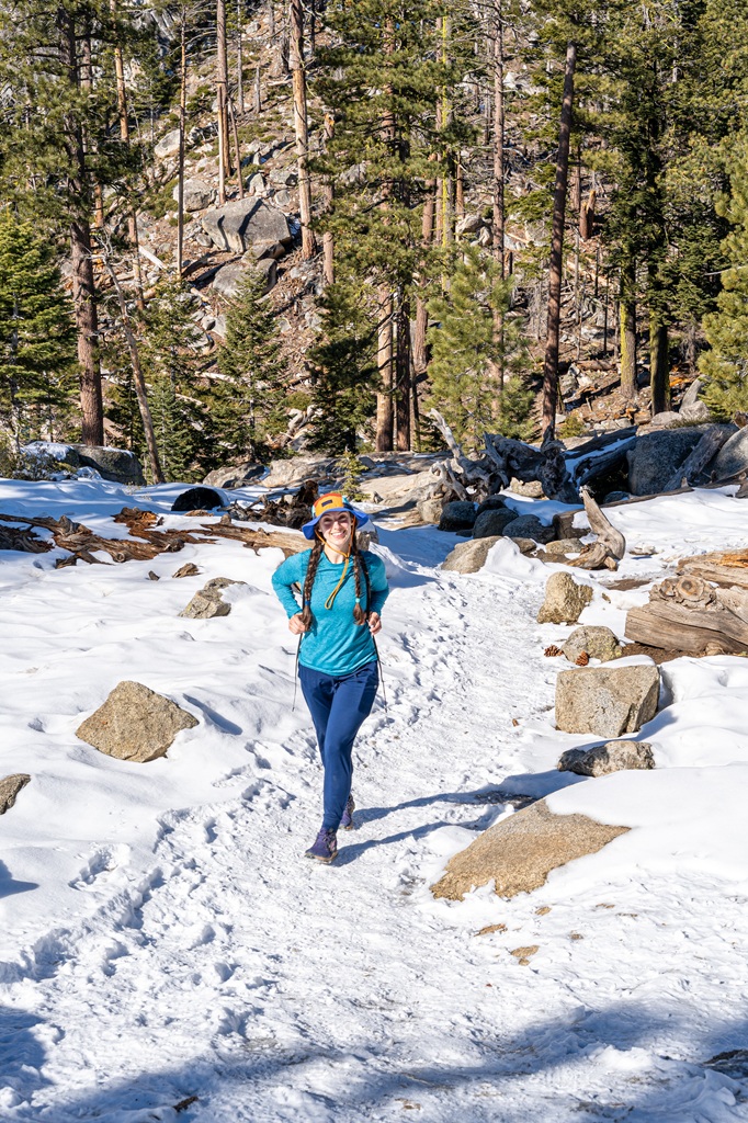 Woman hiking along a snow-covered trail in winter in Yosemite.