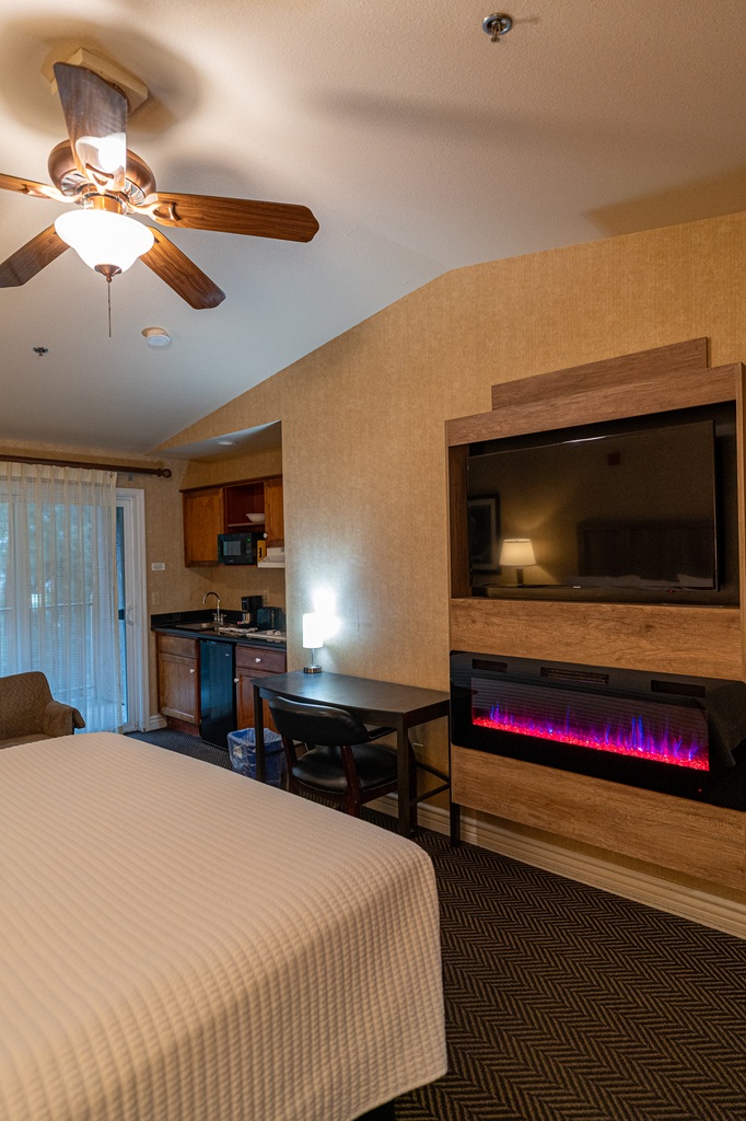 Deluxe Room with fireplace, kitchenette, and balcony with river view at Yosemite View Lodge in El Portal.