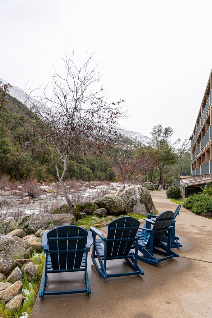 Four rocking chairs to relax in while listening to the Merced River at Yosemite View Lodge.