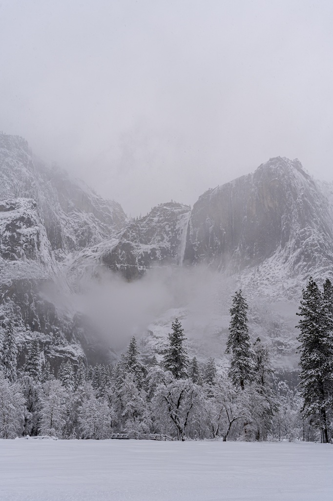 View of Yosemite Falls from Cook's Meadow in snow in Yosemite National Park in mid-winter.
