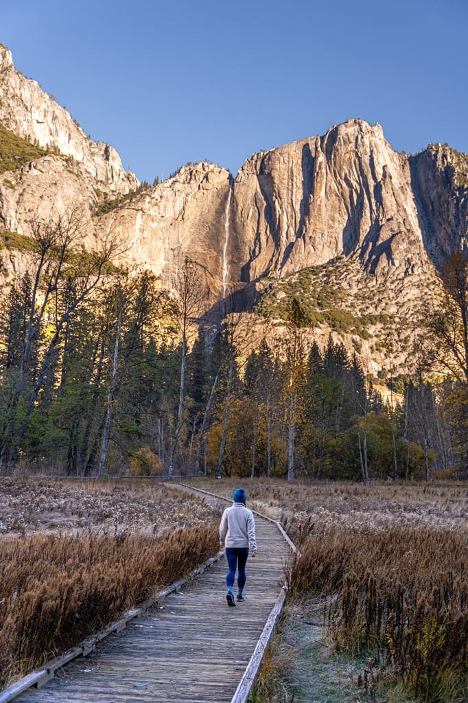 Woman walking on a boardwalk along the Cook's Meadow Loop Trail in Yosemite National Park in late fall.