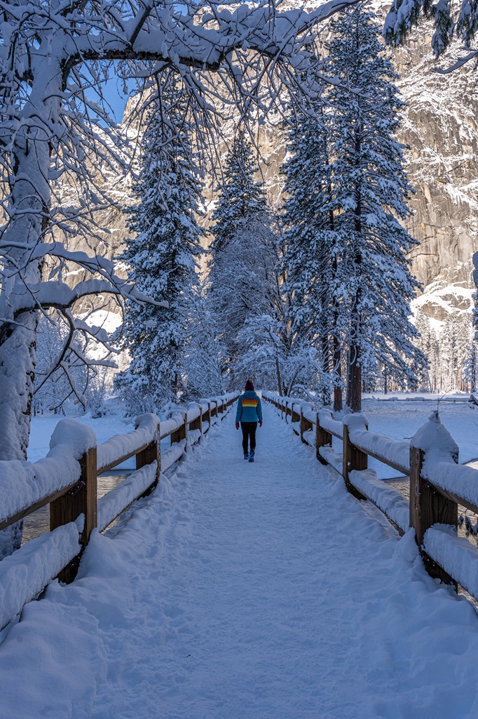 Woman walking on Swinging Bridge in Yosemite Valley in mid-winter.