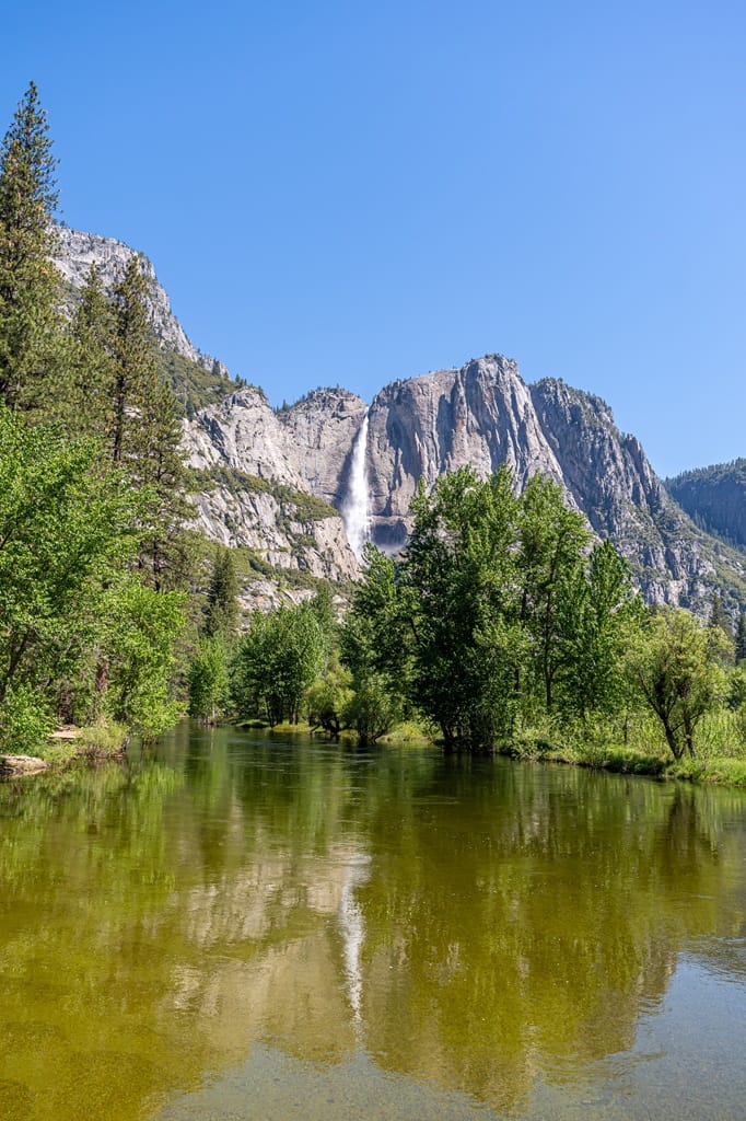 View of Yosemite Falls and Merced River from Swinging Bridge in Yosemite National Park in late spring.