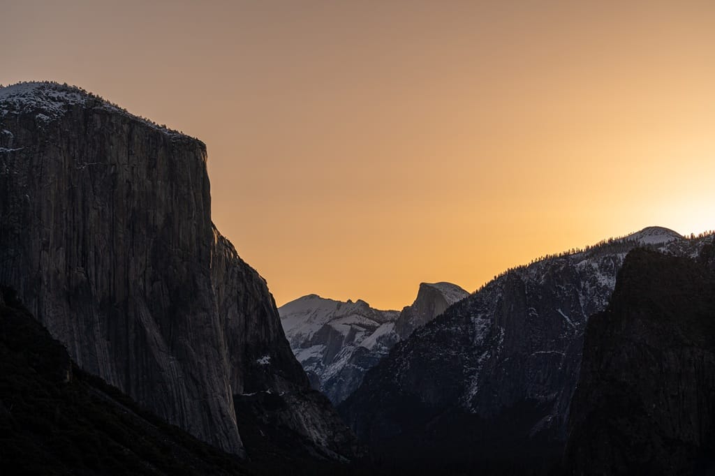 Sunrise at Tunnel View with views of EL Capitan, Half Dome, and Clouds Rest covered in snow in Yosemite National Park in early spring.