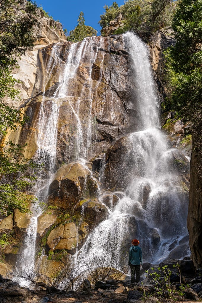 Woman standing in front of Grizzly Falls in Giant Sequoia National Monument.