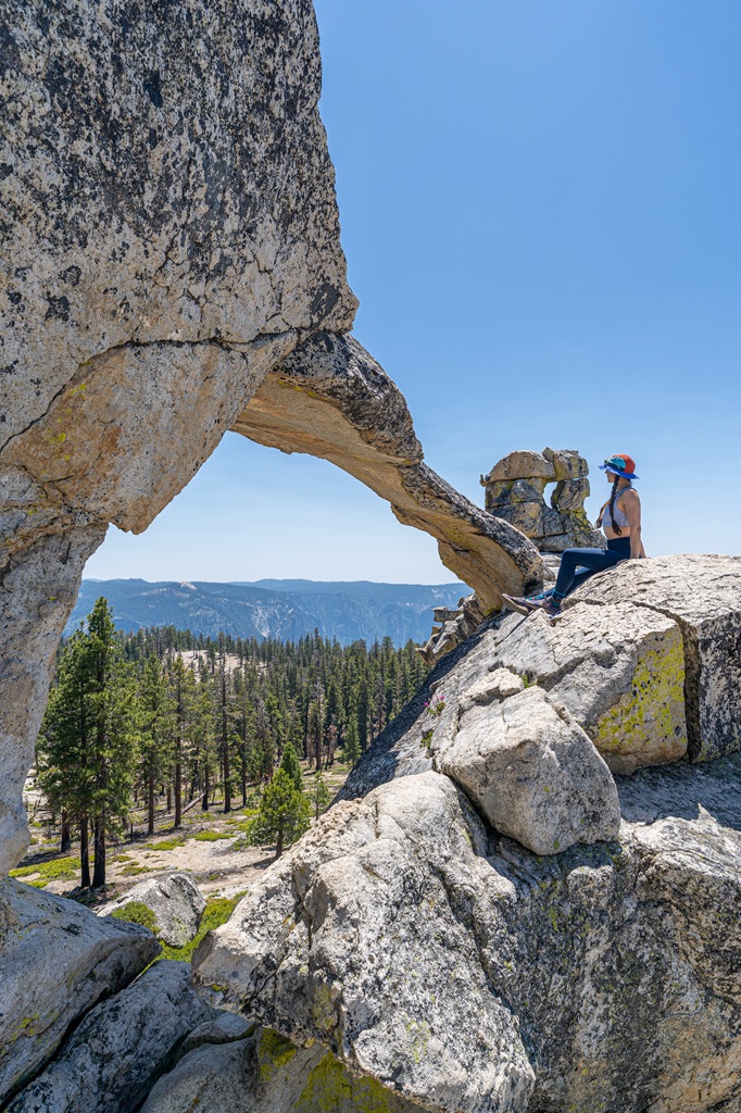 Woman sitting on a rock under Indian Rock in Yosemite National Park.
