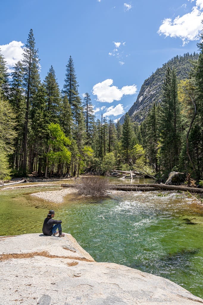 Man sitting on Muir Rock looking at Kings River flowing by in Kings Canyon National Park.