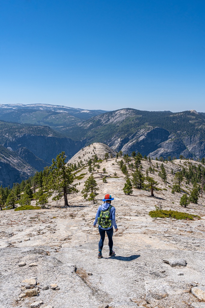 Woman heading down Indian Ridge towards North Dome in Yosemite National Park.