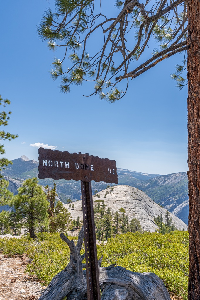 North Dome Trail sign with view of North Dome in the distance.