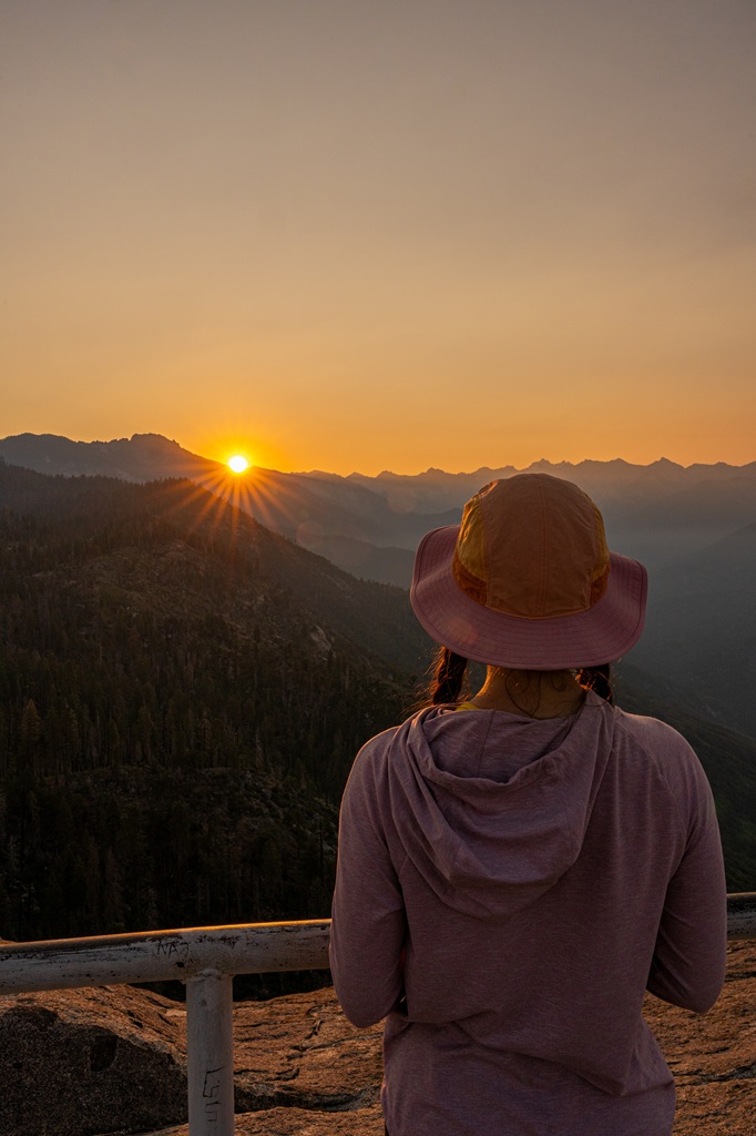 Woman watching the sunrise from Moro Rock in Sequoia National Park.
